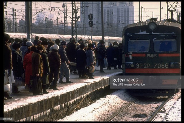 Passengers carrying shopping & overnight-sized bags packing platform, waiting to bd. train at Kursky railway station, Moscow (February 19, 1992).jpg