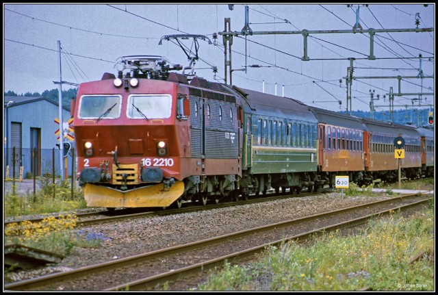 Электровоз NSB El16 2210 с поездом Осло - Гётеборг и прицепным вагоном SZD Осло - Москва на станции Эльвенген, Швеция (фото сделано в июле 1990 года).jpg